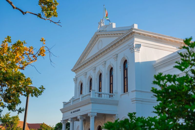 Weißes klassizistisches Universitätsgebäude mit Säulen und Flagge