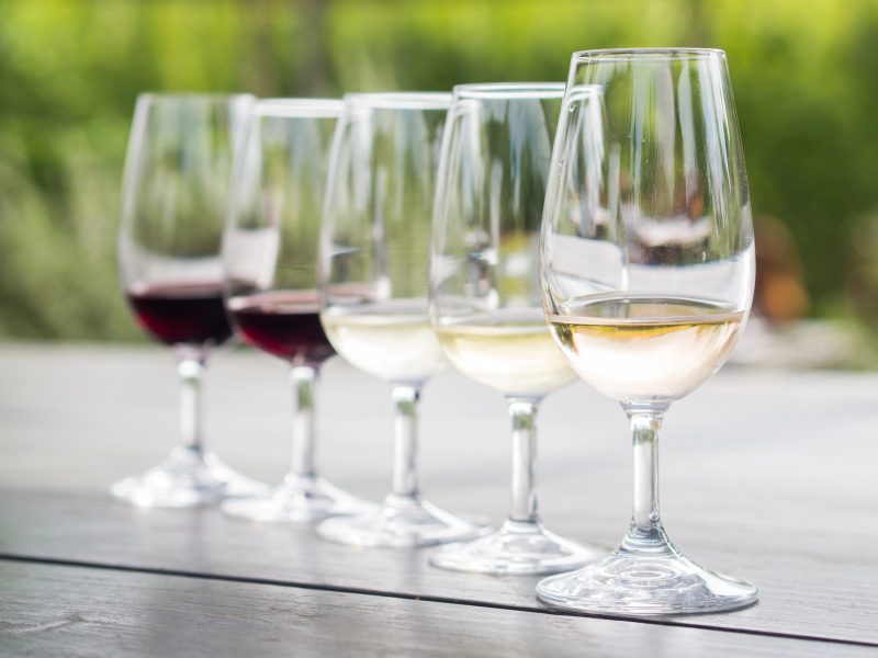 Fünf Weingläser in einer Reihe, von Rotwein bis Weißwein